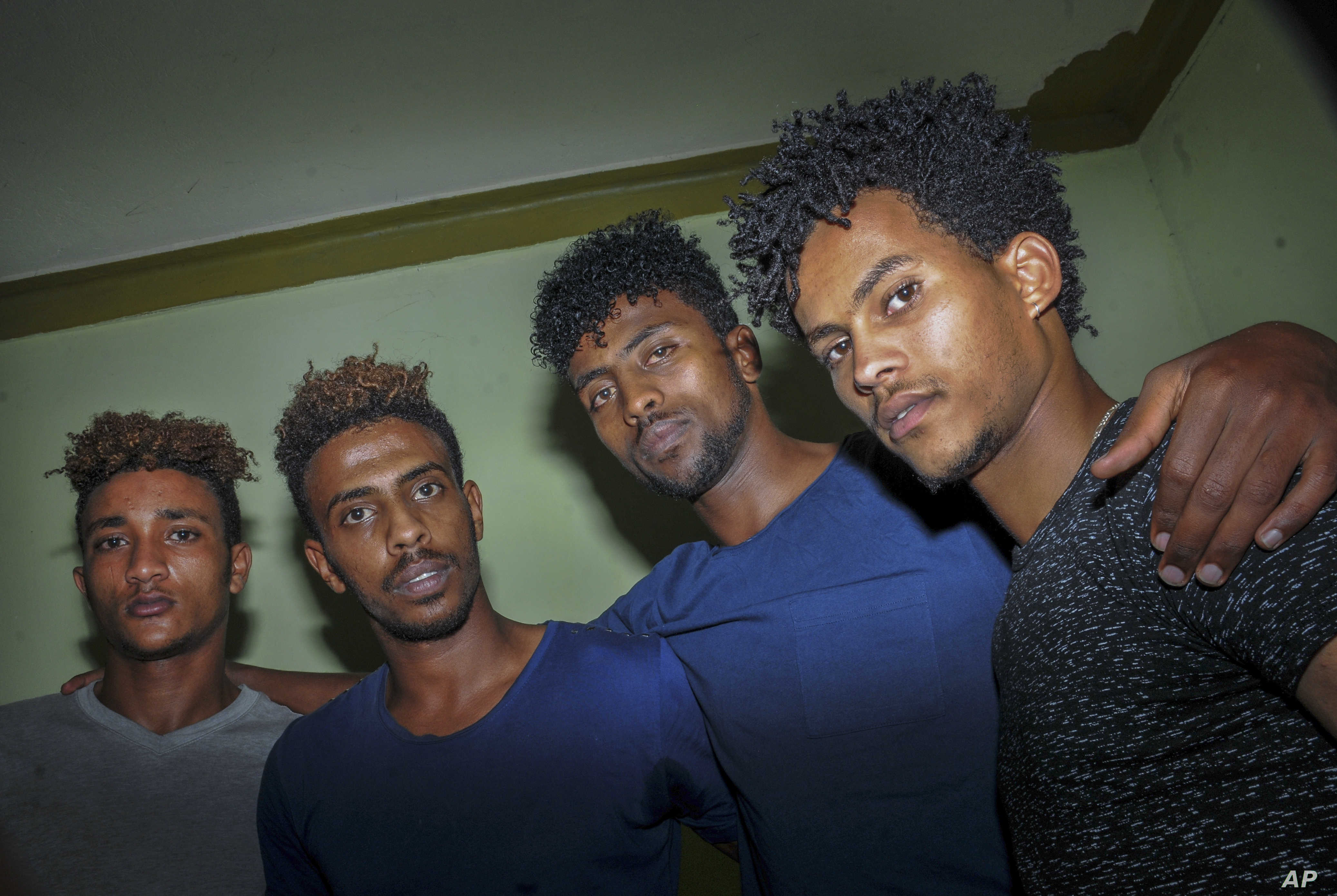 In this photo taken on Thursday, Oct. 10, 2019, from left, Eritrean under-20 soccer players Simon Asmelash Mekonen, Mewael Tesfai Yosief, Hermon Fessehaye Yohannes, and Hanibal Girmay Tekle talk together in a house where they are staying in Uganda. Four young players with Eritrea's national under-20 soccer team have defected during a tournament in Uganda, the latest players to leave one of the world's most tightly controlled regimes. (AP Photo)