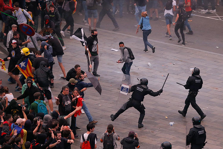 Protesters clash with Spanish policemen outside El Prat airport in Barcelona on October 14, 2019 as thousands of angry protesters took to the streets after Spain's Supreme Court sentenced nine Catalan separatist leaders to between nine and 13 years in jail for sedition over the failed 2017 independence bid. - As the news broke, demonstrators turned out en masse, blocking streets in Barcelona and elsewhere as police braced for what activists said would be a mass response of civil disobedience. (Photo by Pau Barrena / AFP)