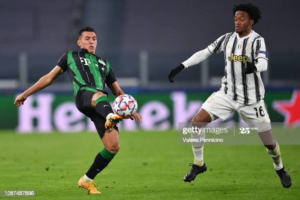 TURIN, ITALY - NOVEMBER 24: Myrto Uzuni of Ferencvaros and Juan Cuadrado of Juventus F.C. battle for the ball during the UEFA Champions League Group G stage match between Juventus and Ferencvaros Budapest at Allianz Stadium on November 24, 2020 in Turin, Italy. Sporting stadiums around Italy remain under strict restrictions due to the Coronavirus Pandemic as Government social distancing laws prohibit fans inside venues resulting in games being played behind closed doors. (Photo by Valerio Pennicino/Getty Images)