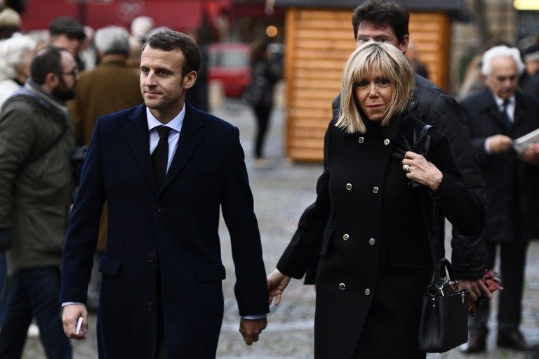 Founder and president of the political movement "En Marche !", and former French Economy Minister, Emmanuel Macron (L) and his wife Brigitte Trogneux leave the Saint-Sulpice church after attending a serice for the funeral of French businessman Henry Hermand, on November 10, 2016 in Paris. / AFP PHOTO / MARTIN BUREAU
