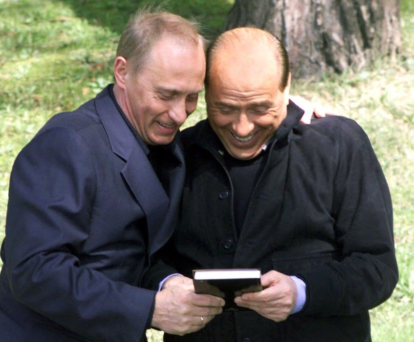 Russian President Vladimir Putin (L) presents Italian Prime Minister Silvio Berlusconi with a book p..