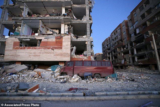 In this photo provided by the Iranian Students News Agency, ISNA, destroyed buildings and a car are seen after an earthquake at the city of Sarpol-e-Zahab in western Iran, Monday, Nov. 13, 2017. A powerful earthquake shook the Iran-Iraq border late Sunday, killing more than one hundred people and injuring some 800 in the mountainous region of Iran alone, state media there said. (Pouria Pakizeh/ISNA via AP)