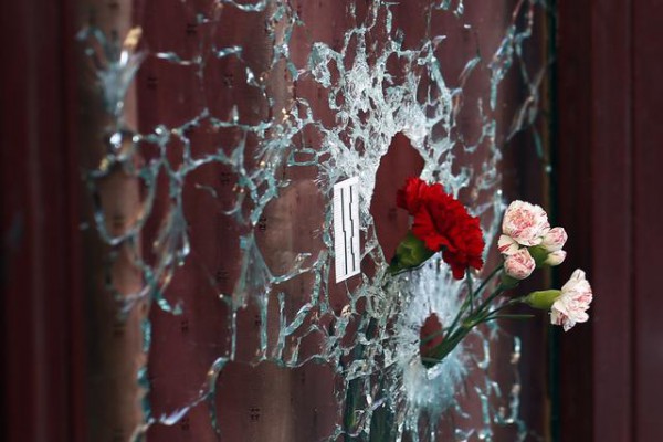 Lule në dritaren e restorantit që u godit nga terroristët në Paris. Foto: (AP Photo/Jerome Delay)