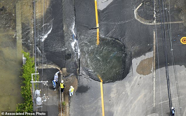 Water floods out from crack in the road, following an earthquake in Takatsuki, Osaka, Monday, June 18, 2018. A strong earthquake knocked over walls and set off scattered fires around the city of Osaka in western Japan on Monday morning.(Yohei/Nishimura /Kyodo News via AP)