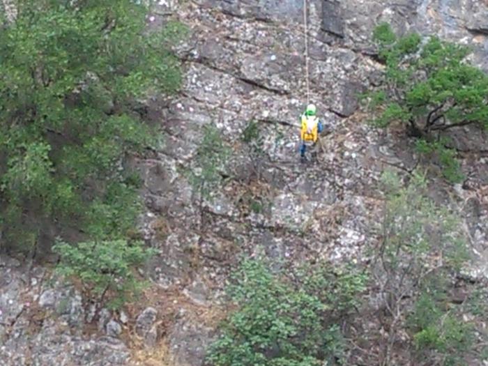 Soccorritore si cala nella gola, Civita (Cosenza), 20 agosto 2018. Sarebbero cinque, secondo la protezione civile nazionale, i morti provocati dall'ondata del torrente Raganello a Civita. Tra loro una giovane ragazza non ancora identificata ed il cui corpo è stato recuperato. Altre 12 persone sono state individuate e sono in corso le operazioni di recupero da parte dei vigili del fuoco e del soccorso alpino. ANSA/CLEMENTE ANGOTTI