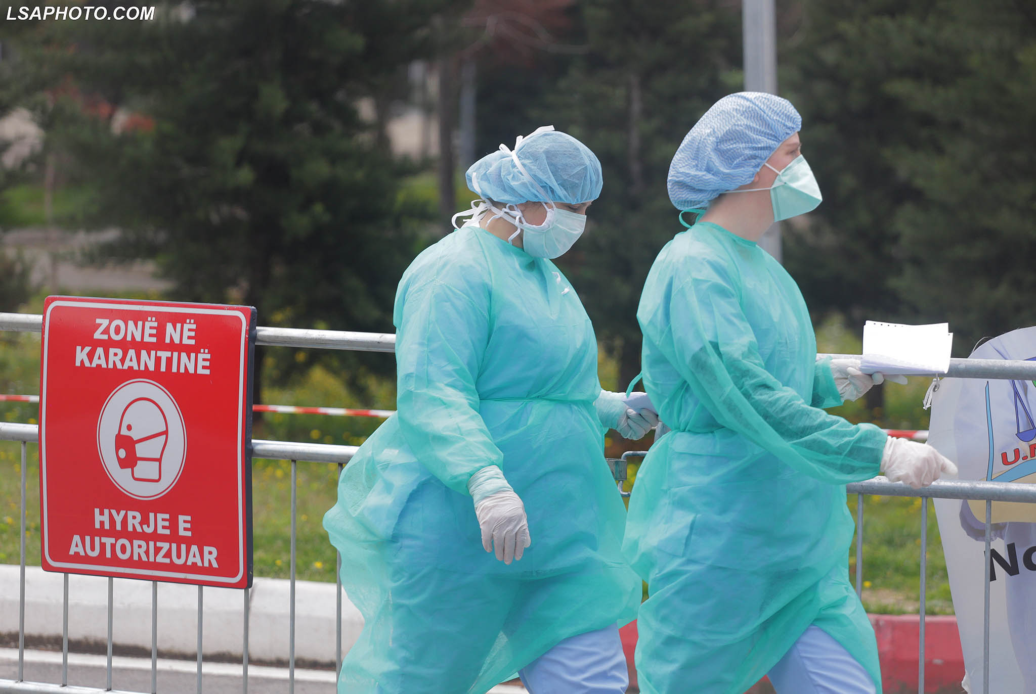 Infermiere me veshje mbrojtese e maska duke ecur ne oborrin e e Sherbimit Infektiv ne Qendren Spitalore Universitare Nene Tereza, QSUT, i cili eshte kthyer ne karantine. Deri tani jane konfirmuar 197 raste me koronavirus ne Shqiperi, nder te cilet 10 kane nderruar jete dhe 33 prej tyre jane sheruar./r/n/r/nNurses wear protecting gear while walking at the Infectious Diseases Ward at Mother Teresa University Hospital Center, QSUT, which has been turned into quarantine. So far, 197 cases of coronavirus have been confirmed in Albania, of which 10 have died and 33 have recovered.