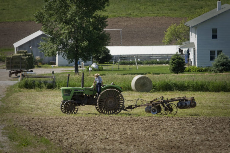 KALONA, USA - JUNE 02: A young Amish farmer dismounts his steel-wheeled tractor in Kalona, Iowa, on June 02, 2017. Amish farmers say they use steel wheels on their tractor so that they aren't tempted to drive it on paved roads. (Photo by Rachel Mummey for The Washington Post via Getty Images)