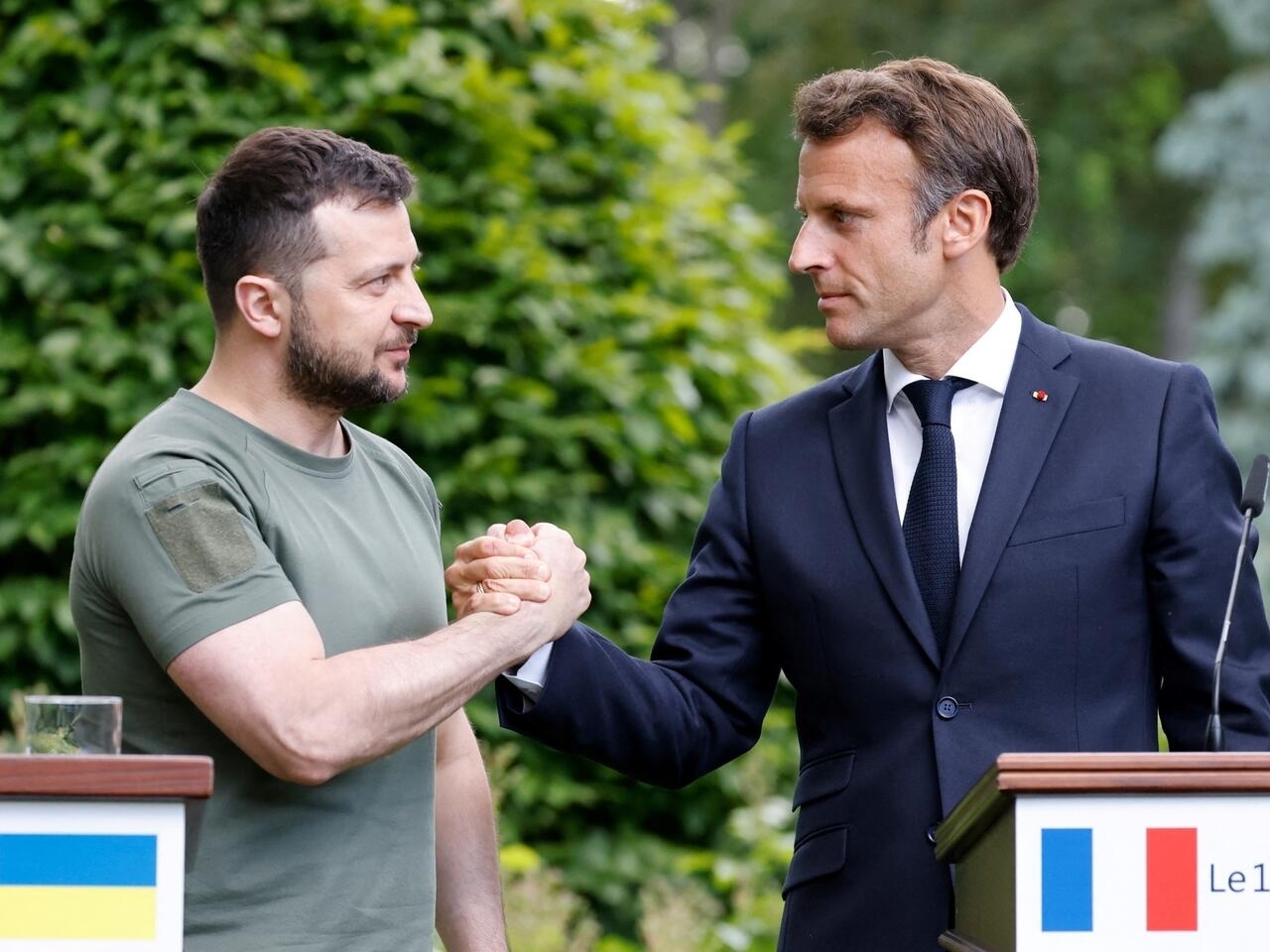 Ukrainian President Volodymyr Zelensky (L) and French Fresident Emmanuel Macron shake hands after giving a press conference in at Mariinsky Palace in Kyiv, on June 16, 2022. - The leaders of major EU powers France, Germany and Italy vowed on June 16 to help Ukraine defeat Russia and to rebuild its shattered cities, in a visit to a war-torn Kyiv suburb. (Photo by Ludovic MARIN / POOL / AFP)