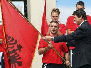 Albania's President Topi hands national flag to the leader of the Albanian National Olympic team in Tirana